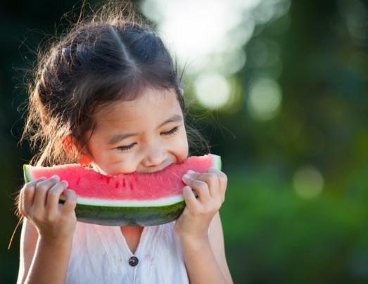 Young girl eating a slice of watermelon